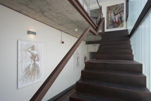a staircase in a house with black stairs and art on the walls at Hostal Emeritae in Mérida