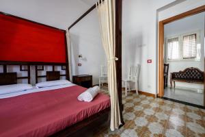 ナポリにあるNapoli Centrale di Fabio e Veronica LTのベッドルーム1室(赤い天蓋付きの大型ベッド1台付)