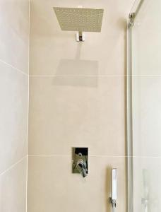 a shower in a bathroom with a light on the wall at L'Ancora appartamenti 3 in Giovinazzo +40 photos