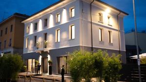 a white building with people standing in front of it at Hotel De Amicis in Moglia