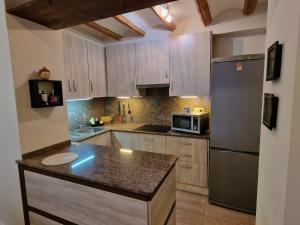 una cocina con nevera de acero inoxidable y armarios en AIRAM Home MENDIZABAL, en Almansa