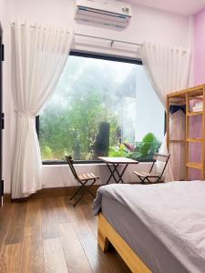 1 dormitorio con cama y ventana grande en Măng Đen Land - Homestay&Coffee, en Kon Von Kla