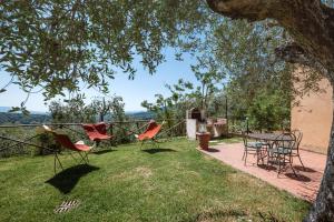 un grupo de sillas y una mesa en un patio en Casamaggio, en San Donato in Collina