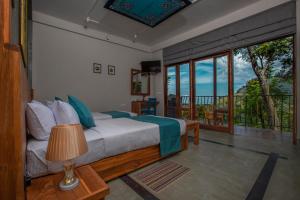 a bedroom with a bed with a view of the ocean at Serenite Ella in Ella