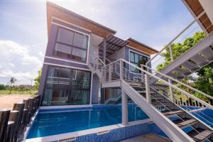una casa con piscina y escalera en เเองเจล่า รีสอร์ท en Pran Buri