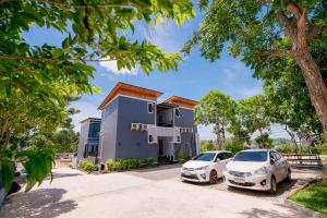 a house with two cars parked in front of it at เเองเจล่า รีสอร์ท in Pran Buri