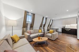 a living room with couches and a table at Limehome Vienna Roßauer Lände in Vienna +41 photos