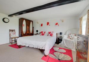 a bedroom with a white bed and a red rug at Tinkers Cottage in Dunwich