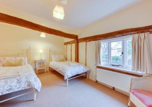 1 dormitorio con 2 camas y ventana en 1 Church Farm en Blythburgh