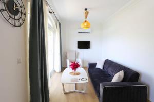 ein Wohnzimmer mit einem Sofa und einem Tisch mit einer Uhr in der Unterkunft Destiny Apart in Kaş