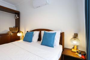 Schlafzimmer mit einem Bett mit blauen und weißen Kissen in der Unterkunft Destiny Apart in Kaş