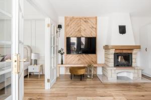 a living room with a fireplace and a tv at Rent like home - Pod Blachówką 3 in Kościelisko
