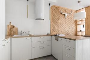 a kitchen with white cabinets and a wooden door at Rent like home - Pod Blachówką 3 in Kościelisko