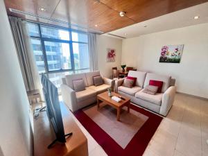 a living room with two couches and a tv at Spirit Tower - 1BR Apartment - Allsopp&Allsopp in Dubai