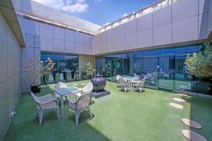 a patio with tables and chairs and a vase at Spirit Tower - 1BR Apartment - Allsopp&Allsopp in Dubai