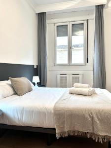 1 dormitorio con 1 cama con 2 toallas en PdV rooms, en Madrid