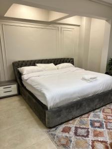 1 dormitorio con 1 cama grande con sábanas blancas en شقة في حي الروضة الراقي en Yeda