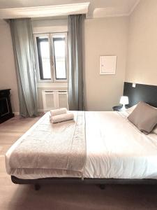 1 dormitorio con 1 cama grande y 2 toallas. en PdV rooms, en Madrid