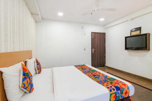 a bedroom with a bed and a tv on the wall at FabHotel Moro Rohini Sector 11 in New Delhi