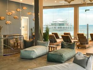 eine Lobby mit Sofas und Stühlen und einem großen Fenster in der Unterkunft Grand Hotel Seeschlösschen Sea Retreat & SPA in Timmendorfer Strand