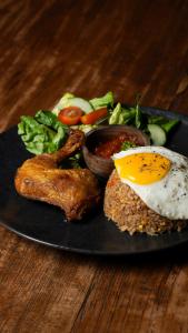 un plato de comida con un huevo y carne y hortalizas en La Nusa Penida Homestay by BIJAK, en Nusa Penida
