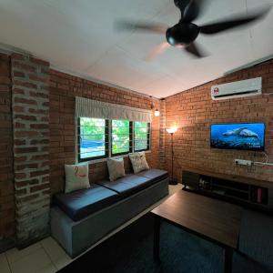 a living room with a couch and a ceiling fan at Kutum's Wooden House - Private Pool, Breakfast & Cafe in Huma