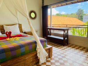 a bedroom with a bed with a canopy at Arjuna Uluwatu Guest House in Uluwatu