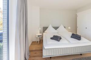 a bedroom with a white bed with two pillows on it at Strandglück in Timmendorfer Strand