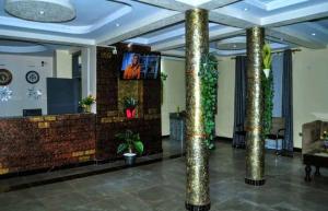 een lobby met zuilen en een televisie in een gebouw bij HOTEL ZEPTAN in Jinja