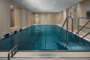 ein großer Pool in einem Gebäude mit einer Treppe in der Unterkunft Harvey Spa Hotel in Franzensbad