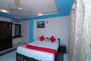 1 dormitorio con 1 cama grande con almohadas rojas en OYO 13161 Apni Havali Hotel & Restaurant, en Rāmpura