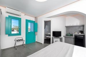 a bedroom with a bed and a green door at Santa Irina Luxury Sunny Lofts in Perivolos