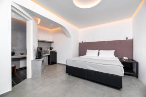 a bedroom with a large bed and a kitchen at Santa Irina Luxury Sunny Lofts in Perivolos