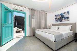 a bedroom with a bed and a blue door at Santa Irina Luxury Sunny Lofts in Perivolos