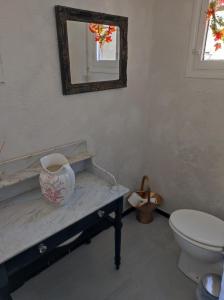 a bathroom with a toilet and a vase on a counter at Chez sylvie et guy in Chignin
