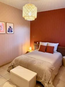 Un dormitorio con una cama grande y una lámpara de araña. en La maisonnette, en Montauban