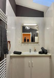 a bathroom with a sink and a mirror at La maisonnette in Montauban