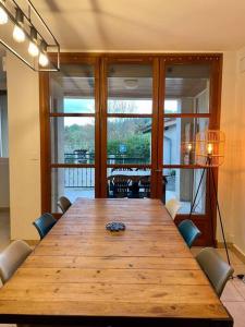 einem großen Holztisch mit Stühlen und einem großen Fenster in der Unterkunft La maisonnette in Montauban