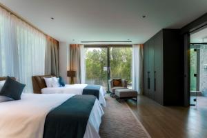 a hotel room with two beds and a window at Nurai Water Villa By Luxury Explorers Collection in Abu Dhabi