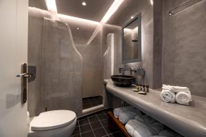 a bathroom with a sink and a toilet and a mirror at Santa Irina Luxury Sunny Lofts in Perivolos