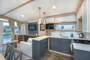 a kitchen and living room with blue cabinets and a couch at Luxury 8 Berth-Wheelchair Access in Port Seton