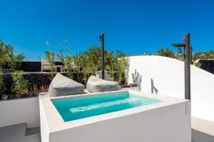 a swimming pool in the middle of a house at Santa Irina Luxury Sunny Lofts in Perivolos
