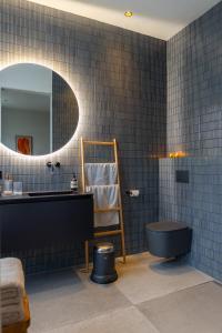 a bathroom with a black toilet and a mirror at Vondel 99 in Amsterdam