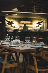 a wooden table with wine glasses on it at Bristol Hotel Podgorica in Podgorica