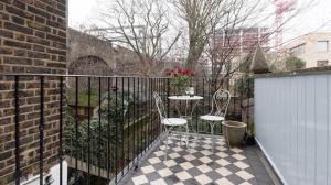 eine Terrasse mit 2 Stühlen und einem Tisch auf einem Zaun in der Unterkunft Spacious 4 bed, Central Camden in London