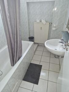 a bathroom with a sink and a tub and a toilet at GZ Hostel Bonn in Bonn
