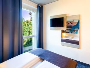 a bedroom with a bed and a window at B&B Hotel Braunschweig-City in Braunschweig