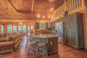 eine Küche und ein Wohnzimmer in einem Blockhaus in der Unterkunft Three Homes- Smoke Rise Lodge and Barn Poppy's Plc in Dandridge + 63 Fotos