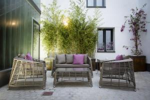 two wicker chairs and a couch on a patio at Hostal Emeritae in Mérida