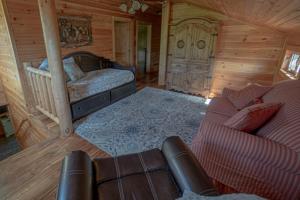 ein Wohnzimmer mit einer Couch und einem Bett in einer Kabine in der Unterkunft Three Homes- Smoke Rise Lodge and Barn Poppy's Plc in Dandridge